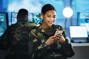 Image showing Phone, military and woman soldier in the control room in uniform for war or battle networking. Happy, smile and young female army warrior typing a message on internet with cellphone for surveillance.