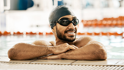 Image showing Happy, man and athlete in swimming pool after training, workout or exercise for wellness, performance or cardio fitness. Swimmer, relax and smile with sports, goggles or cap for competition and race