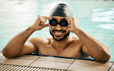 Image showing Happy, man and portrait of athlete in swimming pool with gear for training, workout or exercise for wellness, health or fitness. Swimmer, goggles or smile for sport, challenge or cardio in water polo