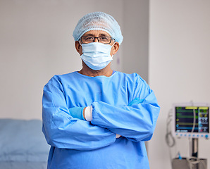 Image showing Surgeon, portrait and man with arms crossed in hospital with confidence in emergency healthcare, medicine or cardiology. Doctor, face mask and pride in surgery, work and operating room or theater