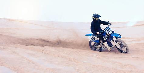 Image showing Dirt, motorbike and athlete driving with speed in sports, adventure and sand in desert or man riding outdoor with sky or nature. Extreme sport, bike or motorcycle drive with helmet, gear or freedom