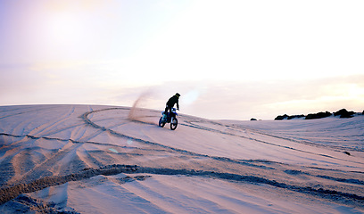 Image showing Driving, sand dust or athlete on motorcycle for adventure, action or fitness in outdoor workout at sunset. Dirt, desert or sports driver on motorbike on dunes in training, exercise or race challenge