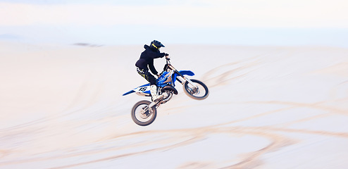 Image showing Sand, jump or athlete driving motorcycle for action, adventure or fitness with performance or adrenaline. Desert, risk or sports person on motorbike on dunes for training, exercise or race challenge