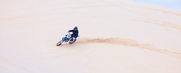 Image showing Desert, sand or driver driving motorbike for action, adventure or fitness with performance or adrenaline. Nature, dirt or sports athlete on motorcycle on dunes in training, exercise or race challenge