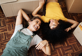 Image showing Top view, lesbian and couple on the floor, boxes and funny with love, bonding and homeowners. Queer people, lgbtq and women on the ground, new apartment and property with achievement and real estate