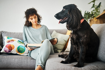 Image showing Woman, reading a book and a dog on home sofa to relax with animal in a living room. Pet owner, happiness and a young person on a couch with love, care and wellness or friendship in a cozy apartment