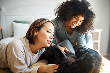 Image showing Dog, bed and happy lesbian couple play in home, morning and relax together. Pet, bedroom and gay women smile with animal, bonding and having fun in healthy relationship, connection and interracial
