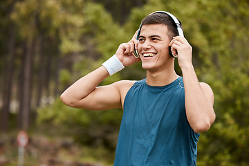 Image showing Fitness, headphones and a man outdoor listening to music or audio with wellness. Happy runner, athlete or sports person in nature park to start exercise, workout or training while streaming radio