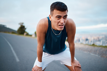 Image showing Sports, nature and man athlete breathing after running for race, marathon or competition training on mountain. Fitness, workout and young male runner on a break for an outdoor cardio exercise.