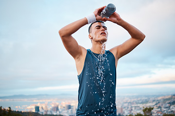 Image showing Fitness, water and fatigue with a sports man outdoor, tired after running a marathon for cardio training. Exercise, health and an exhausted young runner pouring liquid for hydration or refreshment