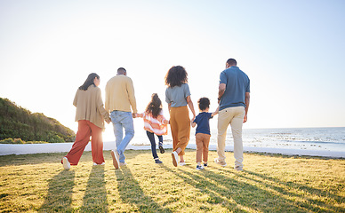 Image showing Nature, walking and back of big family holding hands, unity solidarity or bond on wellness holiday, travel or love. Sunshine flare, sky and relax kids, mom and dad support, trust and journey on grass