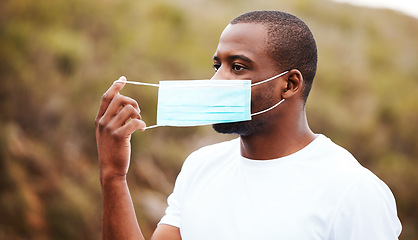 Image showing Covid, outdoor and black man remove mask, safety and pandemic policy with freedom, breathing and decrease infection rates. African person, outside or guy take off face cover, regulations or protected