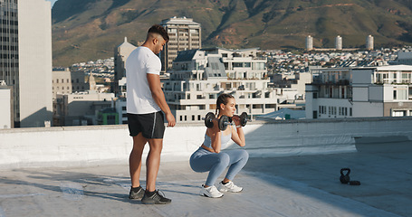 Image showing Personal trainer, fitness and a woman outdoor with dumbbells for exercise, workout or training rooftop. Couple of friends in urban city for squats, strong muscle or bodybuilder and lifting weights