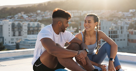 Image showing Couple, fitness and city to rest and talk for exercise, workout or training together on rooftop. Happy man and woman on sports break with a laugh, communication or conversation about wellness