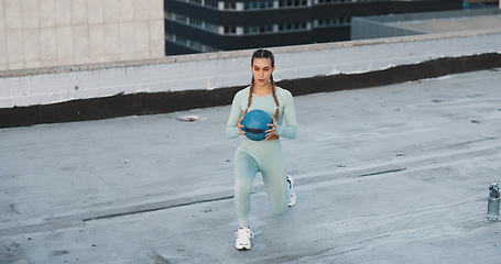 Image showing Fitness, medicine ball and woman athlete in the city for a health, wellness and cardio workout or exercise. Equipment, sports and young female person training on building rooftop in urban town.