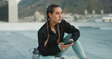 Image showing Social media, fitness and woman with a phone in city for communication, health app and training. Technology, typing and girl thinking of conversation on a mobile app before doing a workout on rooftop