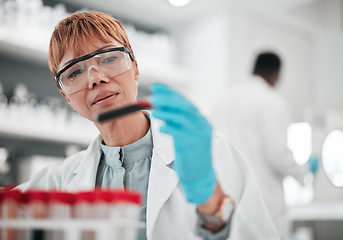 Image showing Woman, scientist and blood sample in lab, ideas and analysis with ppe glasses, safety and test. Science, pathology and expert with thinking, inspection and dna data for medical research in laboratory