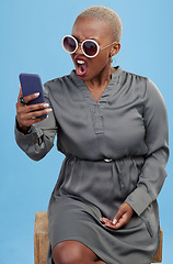 Image showing Phone, news and angry black woman shocked in studio frustrated by glitch, 404 or scam on blue background. Smartphone, fail and African female model annoyed with notification, phishing or spam email