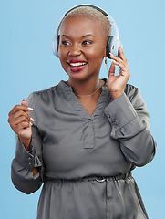 Image showing Black woman, headphones and music, dancing and technology with audio streaming isolated on blue background. Listening to radio, wireless tech for podcast and subscription with media in studio