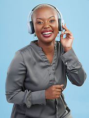 Image showing Black woman, headphones and music, happiness and technology with audio streaming isolated on blue background. Listening to radio, wireless tech for podcast and subscription with media in studio