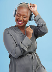 Image showing Headphones, music and black woman on blue background dance for happiness, relax and chill. Happiness, technology and happy African person streaming audio, listening to radio and song in studio