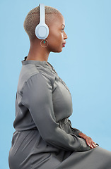 Image showing Headphones, music and profile of black woman on blue background for wellness podcast, relax and chill. Profile, technology and African person streaming audio, listening to radio and song in studio