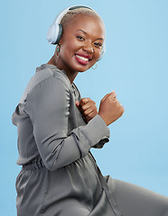 Image showing Portrait, dance and happy black woman with music headphones in studio for audio streaming on blue background. Radio, face and African female model smile for podcast earphones, track or playlist