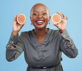 Image showing Happy black woman, portrait and orange for vitamin C, natural nutrition or diet against a studio background. Portrait of African female person smile with healthy organic citrus fruit in body wellness