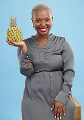 Image showing African woman, pineapple and studio portrait for choice, health and nutrition by blue background. Girl, fruit and happy with decision for diet, eating and vegan food for digestion, vitamins or fiber