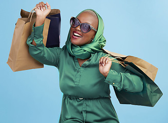 Image showing Shopping bag, studio smile and black woman excited for luxury fashion spree, mall store sales or commerce deal. Retail therapy package, market gift choice and rich African customer on blue background