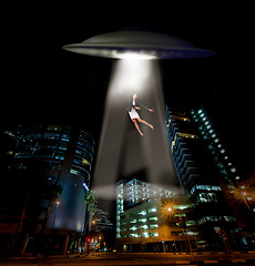 Image showing UFO spaceship, person and abduction in street, city and tractor beam for abduction, search and light. UAP ship, flying saucer and lights in dark cityscape, metro and cbd for galaxy, flight or woman