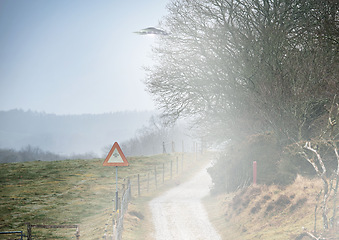 Image showing UFO sign, spaceship and mist road in nature for alien warning, science fiction and abduction. Area 51, travel and signage for extraterrestrial caution in countryside, meadow and natural landscape