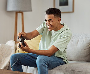 Image showing Happy man, video games and playing on sofa with controller in living room for fun online match at home. Young male person enjoying game time on console for friendly competition or esports in house