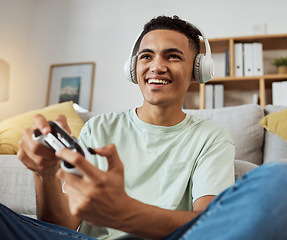 Image showing Home, game controller and man with headphones, relax and connection on a couch, sound and internet. Happy person, gamer and guy on a sofa, playing online and headset with audio, smile and esports