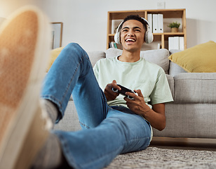 Image showing Headphones, floor and man happy for video game online with controller in living room excited for virtual challenge in home. Internet, user experience and person or gamer streaming sports games