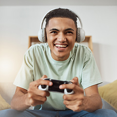 Image showing Happy, game controller and man with headphones, listening or relax on a sofa, connection or internet. Person, gamer or guy playing online, home or headset with sound, happiness or console for esports