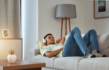 Image showing Man on sofa with headphones, relax and sleep in living room with chill sound, streaming or podcast meditation. Zen, music and person on couch with earphones, peace and calm audio for wellness in home