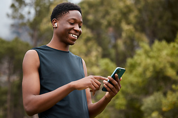 Image showing Earphones, phone and a man outdoor for fitness and listening to music. Happy runner, athlete or african sports person in nature to start exercise, workout or training and streaming radio online