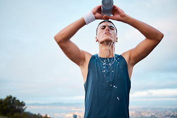 Image showing Exercise, water and fatigue with a sports man outdoor, tired after running a marathon for cardio training. Fitness, health and an exhausted young runner pouring liquid for hydration or refreshment