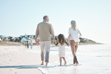 Image showing Relax, holding hands and grandparents with child at beach for travel, love and support. Summer vacation, care and retirement with family walking on seaside holiday for adventure, bonding and peace