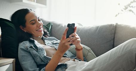 Image showing Woman, phone texting and home with social media post, networking and online on a sofa. Mobile app, happy message and typing on a living room couch with digital entertainment and tech in a house