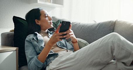 Image showing Woman, thinking and typing on smartphone on sofa, scroll social media and reading notification at home. Cellphone, relax and search connection, download digital app and mobile contact in living room