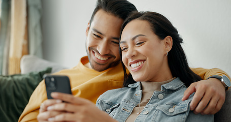 Image showing Couple, smile and talking on sofa with phone for social media post, subscription and reading funny notification. Happy man, woman and hug with smartphone for meme, games app and relax in living room