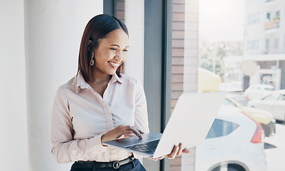 Image showing Woman in office with smile, holding laptop and reading email, HR schedule or online for feedback at window. Internet, networking and communication on website, happy person and human resources agency