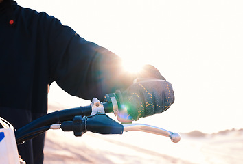Image showing Hand, bike and flare with a sports person closeup outdoor for an off ride race or competition on sand. Motorcycle, handle and control with a rider in the desert for speed, power or adrenaline