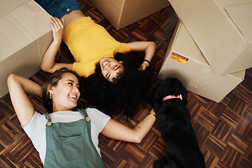 Image showing Lesbian couple, moving and boxes on floor with dog in home, living room or lgbt people relax together with puppy or pet. Love and happiness in new house or above women with animal or property