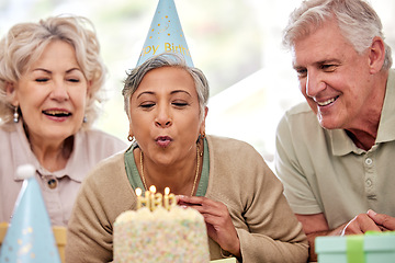 Image showing Senior woman, friends and birthday cake for candles, wish and excited with celebration in nursing home. Elderly group, people and together for party, event and blowing flame with retirement