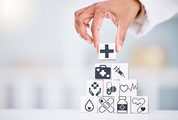 Image showing Hands, healthcare and a building blocks tower in a hospital with a doctor closeup for health insurance. Medicine, icon and symbol with a medicine professional in a clinic for cardiology or treatment