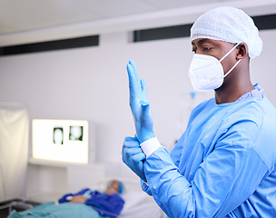 Image showing Doctor, man and surgery, put glove on hand and start operation with face mask, PPE and healthcare at hospital. Surgeon ready for treatment, health and medical professional with patient for wellness