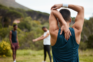 Image showing Stretching arm, fitness and exercise with a man outdoor for health and wellness. Behind runner, athlete or sports person in nature park to start morning run, workout or training with muscle warm up